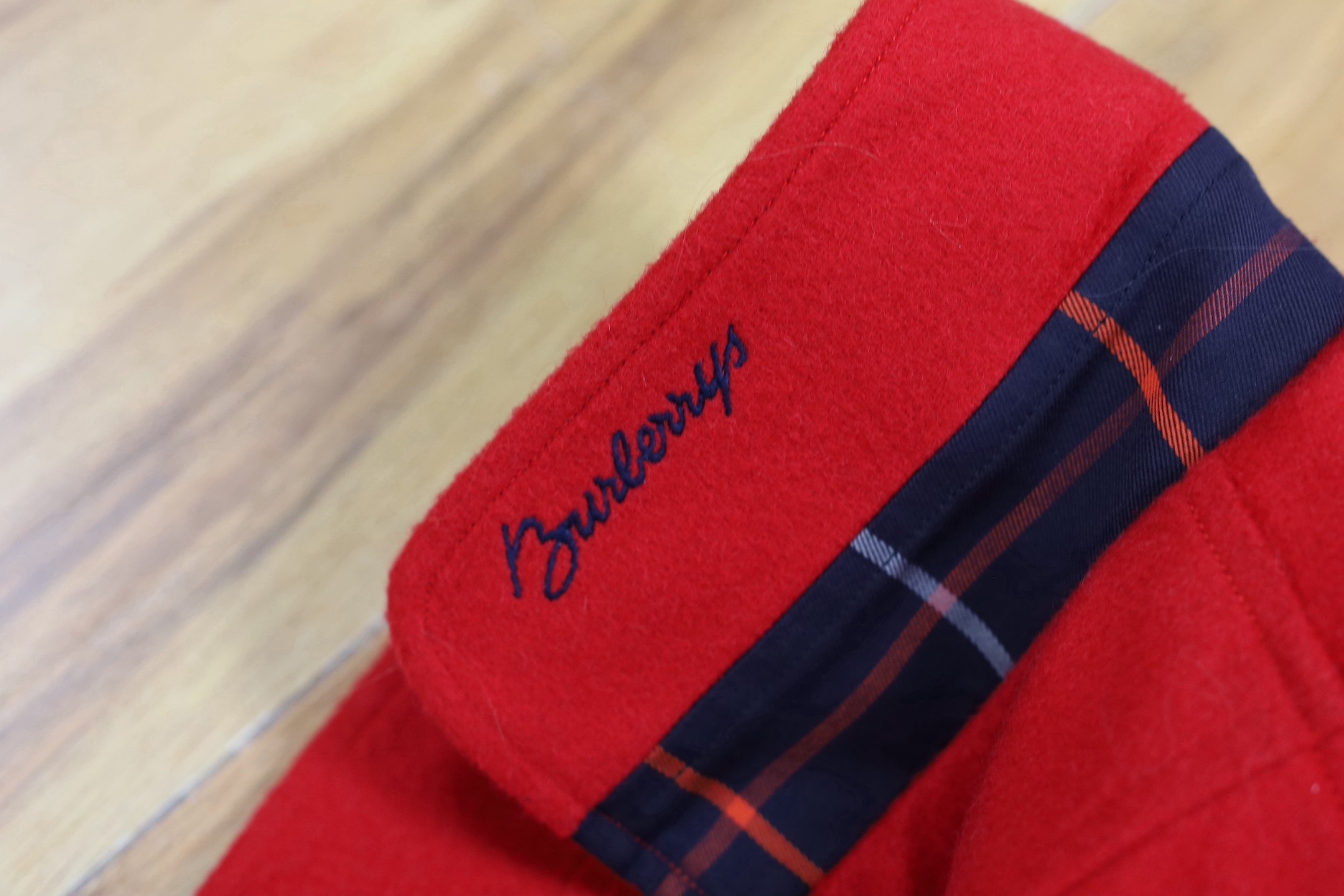 Two vintage Burberry items of clothing: a pleated skirt and a red Harrington jacket